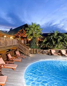 Knysna Log-Inn Hotel في كنيسنا: منتجع فيه مسبح وكراسي ومبنى