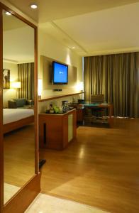a hotel room with a television and a bed at Radisson Blu Hotel Chennai City Centre in Chennai