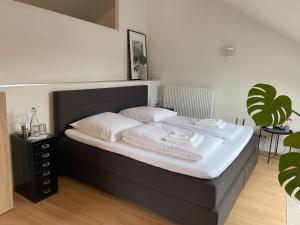 uma cama com lençóis brancos e almofadas num quarto em Ferienwohnung I Ferienhaus am Bodensee I Meersburg I Sauna I Fitness em Meersburg