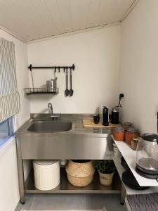 a kitchen with a sink and a counter with pots and pans at תל שיבן אירוח בשעל in Sha'al