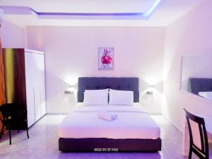 sypialnia z dużym łóżkiem z białą pościelą w obiekcie Tokman Inn w mieście Pantai Cenang