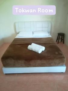 a white bed with a white towel on it at Tokman Inn in Pantai Cenang