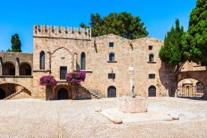 a large brick building with a fountain in front of it at Colourful Home, Medieval Town Rhodes in Rhodes Town +7 photos