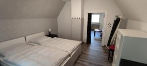 ein Schlafzimmer mit einem weißen Bett in einem Zimmer in der Unterkunft Haus Kunterbunt in Mehlingen