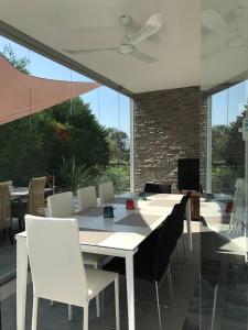a dining room with a white table and white chairs at Super Villa With Private Pool in Isola Albarella in Isola Albarella