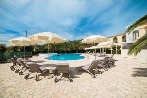 a group of chairs and umbrellas next to a pool at Hotel Ristorante Il Vascello in Costa Rei