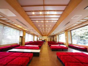 a large room with red seats and windows at Shiobara Onsen Yashio Lodge in Nasushiobara