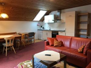 a living room with a couch and a table and a kitchen at Ferienwohnung und Zimmer Kassar Bikertipp in Mauterndorf