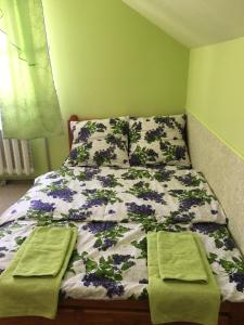 ein Bett mit zwei grünen Handtüchern darüber in der Unterkunft У Ондраша in Jassinja