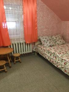 a bedroom with a bed and a table and a window at У Ондраша in Yasinya