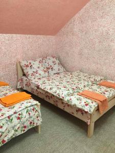 2 Einzelbetten in einem Zimmer mit rosa Wänden in der Unterkunft У Ондраша in Jassinja