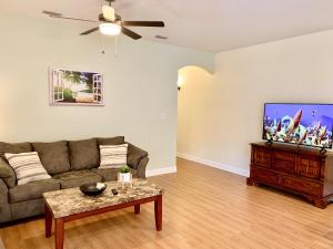a living room with a couch and a flat screen tv at Cape Canaveral near Beach House in Cape Canaveral