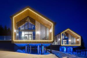 a home lit up in the snow at night at Villas Fomich in Bukovel