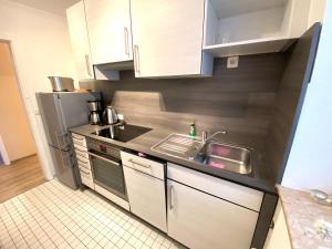 eine Küche mit Spüle und Kühlschrank in der Unterkunft Max & Moritz, App 1 in Grömitz