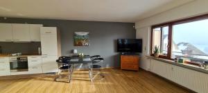 eine Küche mit einem Tisch und einem TV im Zimmer in der Unterkunft Schwarzwald-Blick Lenzkirch-Saig in Lenzkirch