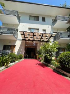 a red carpet path in front of a building at Aparthotel Vila Tufi in Velipojë