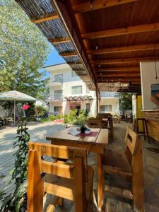 a wooden table and chairs on a patio at Aparthotel Vila Tufi in Velipojë