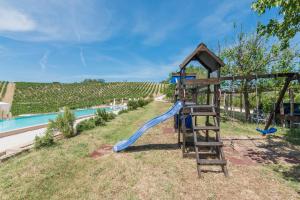einen Spielplatz mit blauer Rutsche neben einem Pool in der Unterkunft Casali Costadoro in Acquaviva Picena