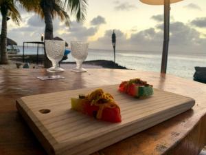a cutting board with food on a table near the ocean at Penthouse Prikichi D2 in Kralendijk
