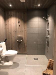 uma casa de banho com um chuveiro, um WC e um lavatório. em Hytte på Myhre Gård em Skammestein