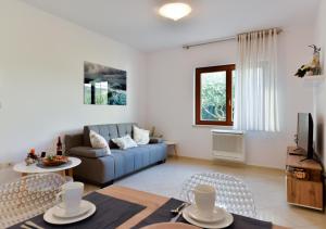 un soggiorno con divano blu e sedie di Apartments Leona a Umag (Umago)