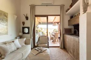 een woonkamer met een witte bank en een glazen schuifdeur bij Romantico Appartamento Vista Mare in Porto Pozzo