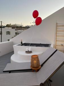 a room with a table and two red balloons at Thallos Cave House and Apartments in Karterados