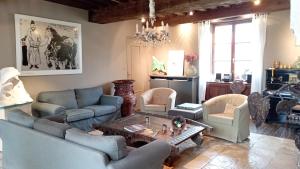 a living room with couches and chairs and a table at La Vallée Verte in Grandchamp