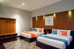 Habitación de hotel con 2 camas y ventana en Sans Hotel Empress Simpang Lima en Semarang