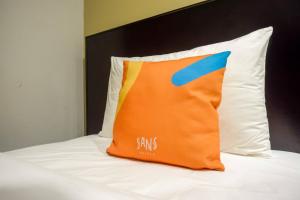 Postel nebo postele na pokoji v ubytování Sans Hotel Empress Simpang Lima