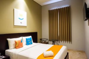Postel nebo postele na pokoji v ubytování Sans Hotel Empress Simpang Lima