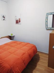 un edredón naranja en una cama en un dormitorio en Ca la Nuri Pis 2 con Vistas al Mar, en Llançà