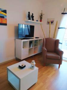 sala de estar con TV, silla y mesa de centro en Ca la Nuri Pis 2 con Vistas al Mar, en Llançà