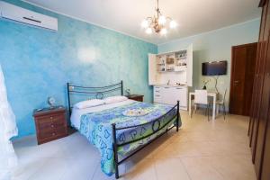 a bedroom with a bed with a blue wall at Sicily in Love - Rooms & Breakfast in Taormina