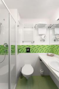a bathroom with a toilet and a sink and a shower at Spa Resort Sanssouci in Karlovy Vary