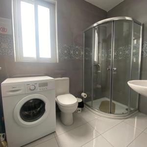 a bathroom with a washing machine and a toilet at F9-2 Room 2 single beds shared bathroom in shared Flat in Msida