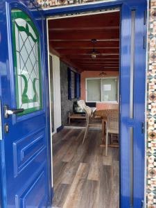 a blue door leading into a dining room with a table at Azores Residence in Pesqueiro