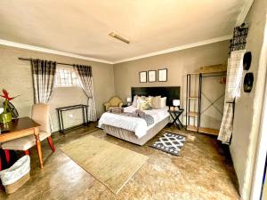 a bedroom with a bed and a table and a desk at Studio Kay in Benoni