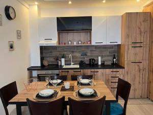 eine Küche mit einem Holztisch und Stühlen in der Unterkunft Milmari Apartman Haski N55 in Kopaonik