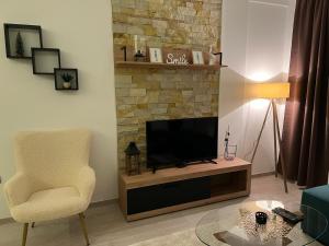 ein Wohnzimmer mit einem TV und einem Stuhl in der Unterkunft Milmari Apartman Haski N55 in Kopaonik