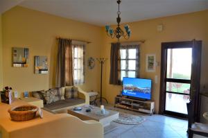 a living room with a couch and a tv at Vineyards Hill Villa in Megalochori