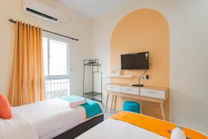 una camera con 2 letti e una scrivania con TV di Sans Resort Parung Bogor a Bogor