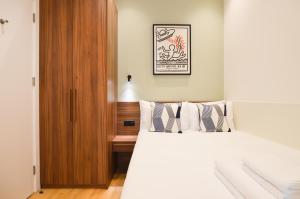 a bedroom with a bed and a picture on the wall at Shepherds Bush Green Serviced Apartments by Concept Apartments in London