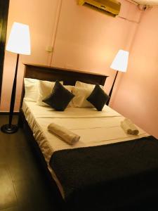 a bedroom with a large bed with two lamps at Araliya hotel in Gampaha