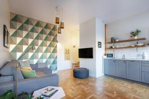 Il comprend un salon avec un canapé et une cuisine. dans l'établissement Art & Comfort Home, à Kaunas