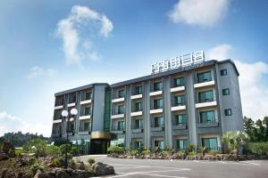 a large building with a parking lot in front of it at Familia Hotel in Seogwipo