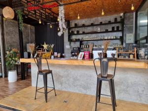 a bar with two chairs in front of a counter at TT Naiyang Beach Phuket in Nai Yang Beach