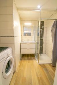 a bathroom with a washing machine and a shower at F2 101 neuf proche gare TGV, A36 et commerces in Botans