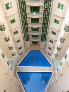 a pool in the middle of a building at Oryx Tower in Manama