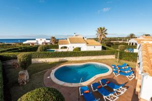 Villa con piscina y tumbonas en Villa Menorca Fucsia by Mauter Villas, en Cala'n Bosch